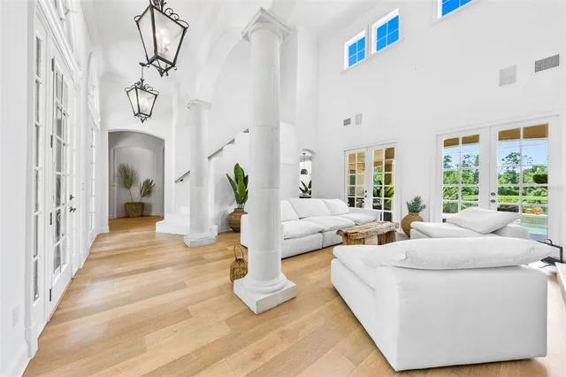 a living room with furniture fireplace and large windows