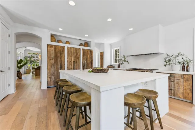 a kitchen with stainless steel appliances kitchen island a table and chairs in it