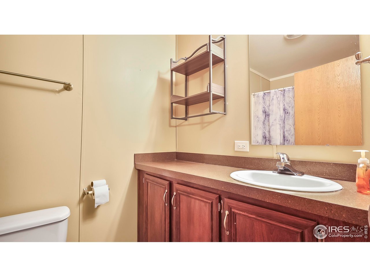 230 North 2nd Street, Unit 72 Berthoud, CO 80513 - Photo 7 of 11 a bathroom with a sink a toilet and mirror