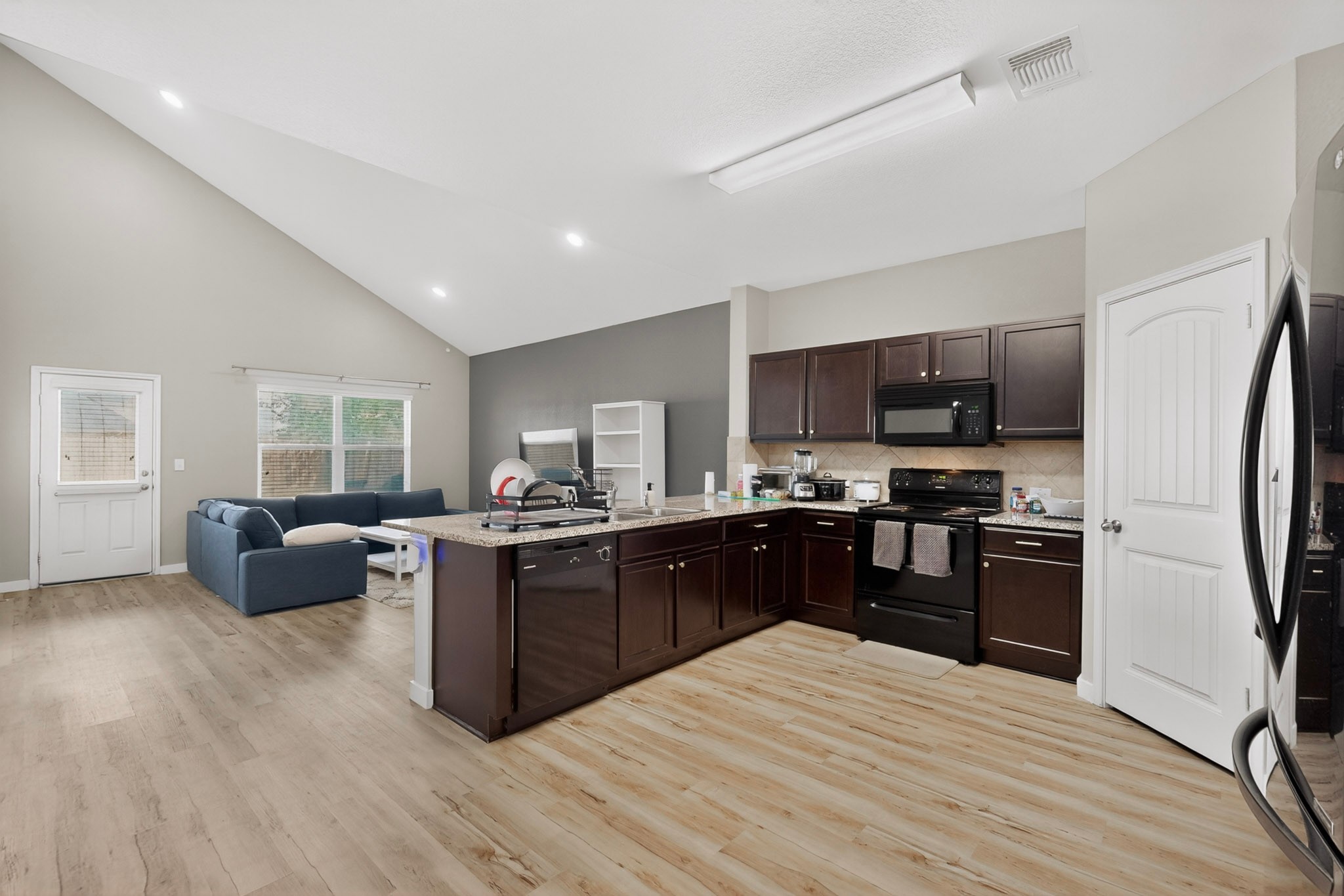 14513 Esker Road Manor, TX 78653 - Photo 10 of 38 An open-concept design with vaulted ceilings merges kitchen and living spaces for effortless entertaining.