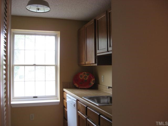 7721 Kingsberry Court Raleigh, NC 27615 - Photo 9 of 11 Galley kitchen with lots of cabinet space and lots of light from window.