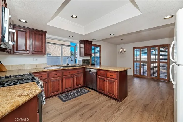 a kitchen with stainless steel appliances granite countertop wooden cabinets a stove a sink and a refrigerator