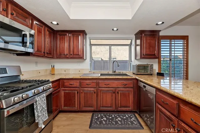 a kitchen with stainless steel appliances granite countertop a stove sink and cabinets