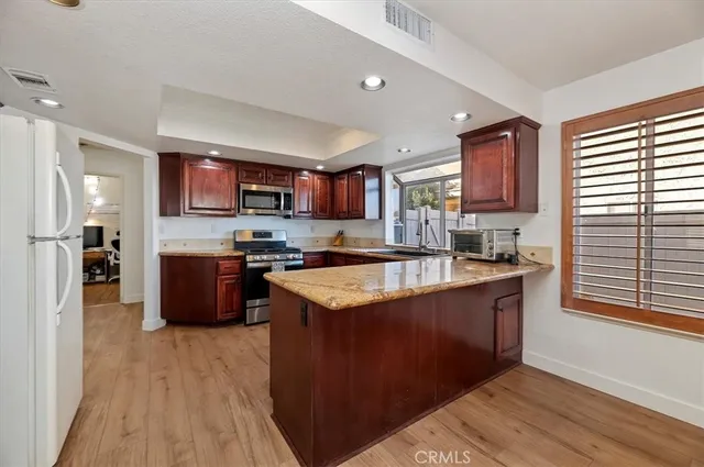 a kitchen with stainless steel appliances granite countertop a stove a sink and a refrigerator