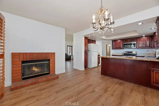 a open kitchen with stainless steel appliances granite countertop a fireplace a stove and a wooden floors