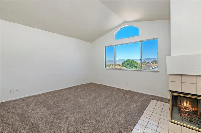 an empty room with windows and fireplace