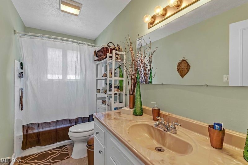 7760 York Road Cleveland, OH 44130 - Photo 16 of 39 Full bath with shower / tub combo, a textured ceiling, vanity, and toilet
