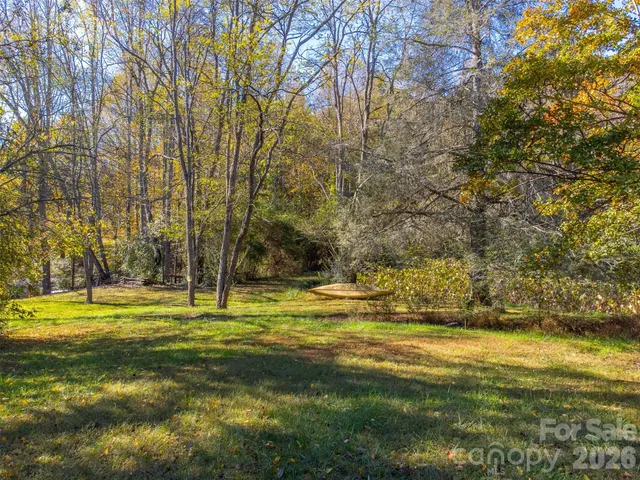 a backyard of a house with lots of plants and tree