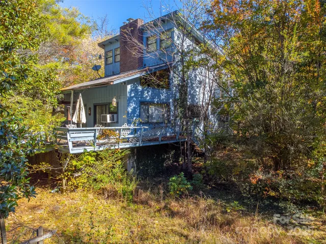 a backyard of a house with lots of plants and tree