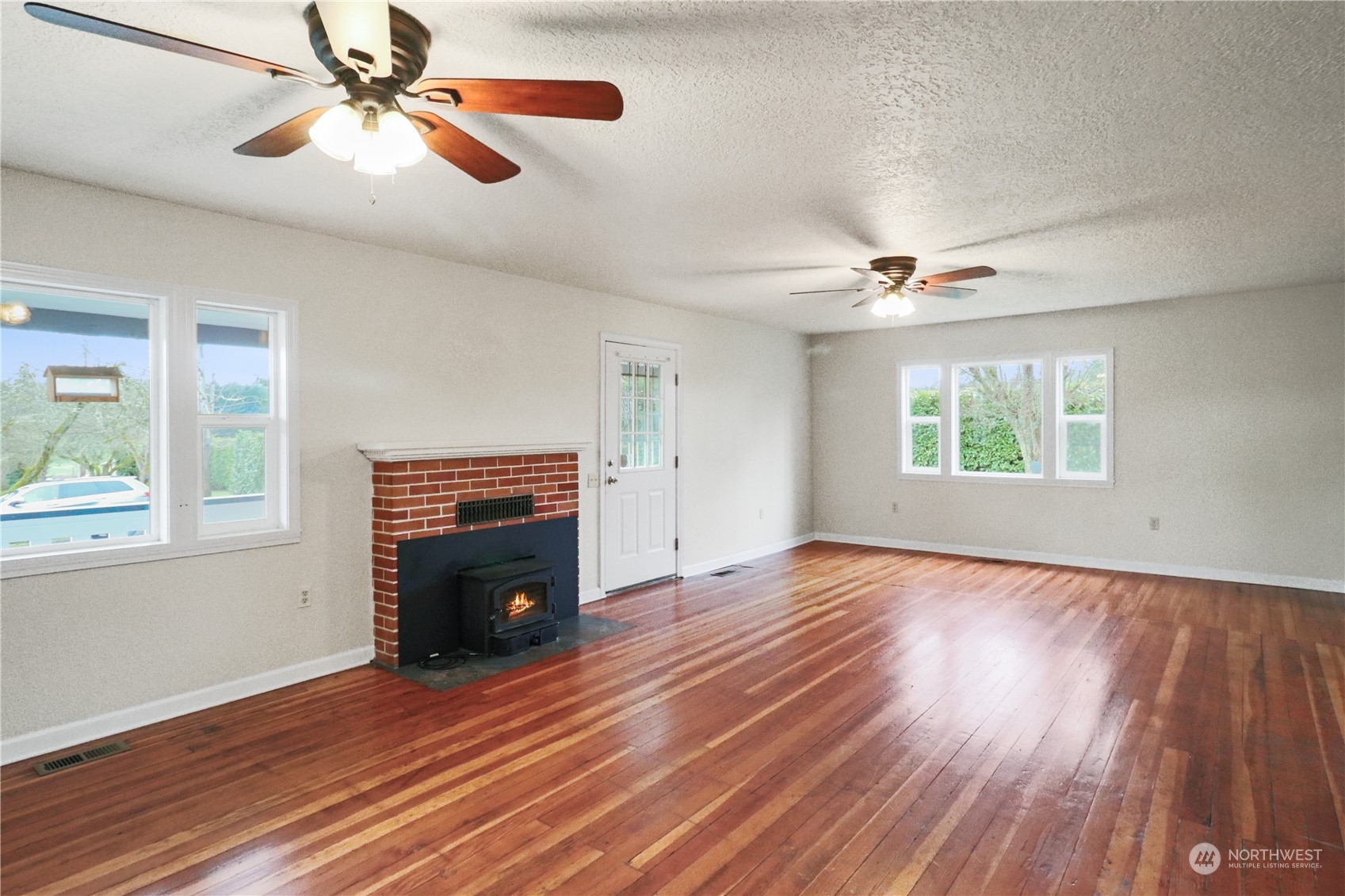 203 Stearns Road Chehalis, WA 98532 - Photo 11 of 34 a view of an empty room with wooden floor fireplace and a window