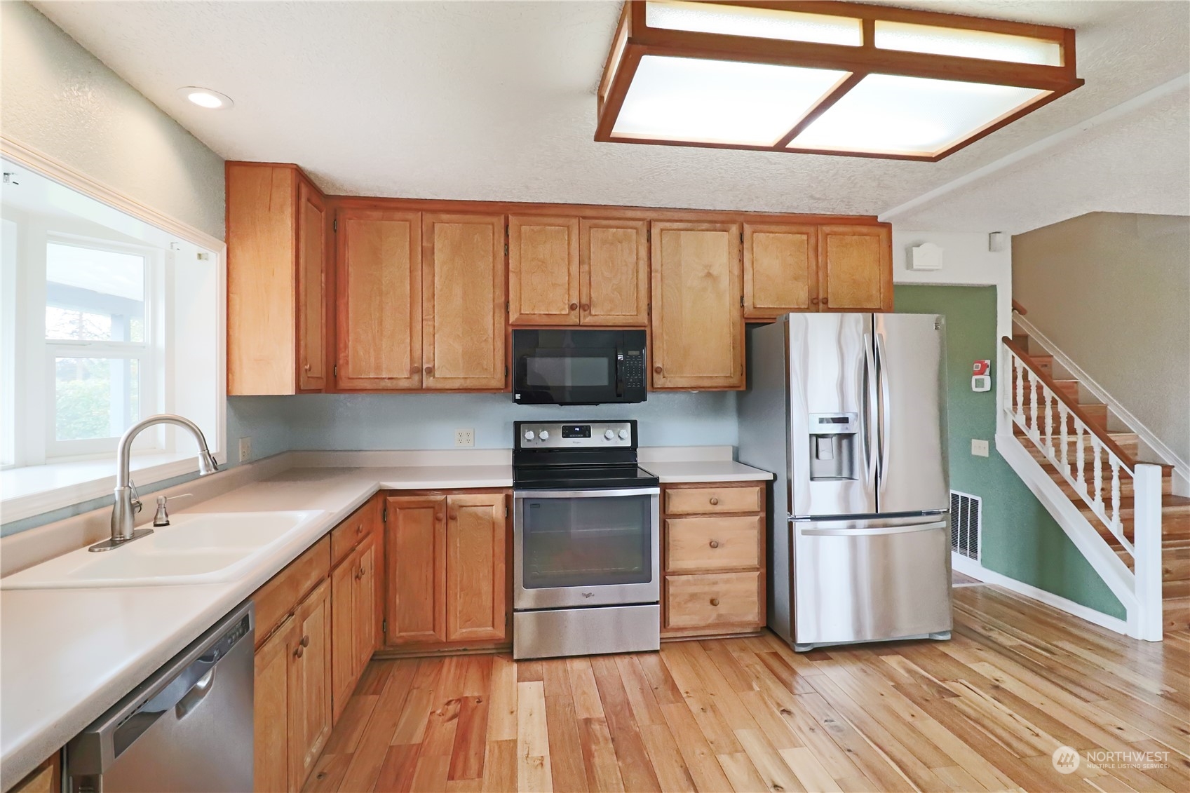 203 Stearns Road Chehalis, WA 98532 - Photo 6 of 34 a kitchen with wooden floors and stainless steel appliances