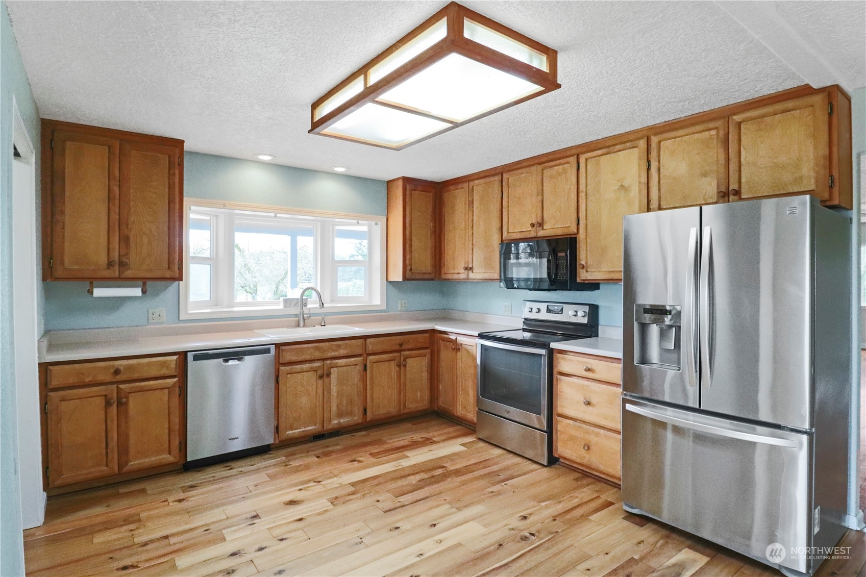 203 Stearns Road Chehalis, WA 98532 - Photo 7 of 34 a kitchen with granite countertop stainless steel appliances a refrigerator cabinets and wooden floor