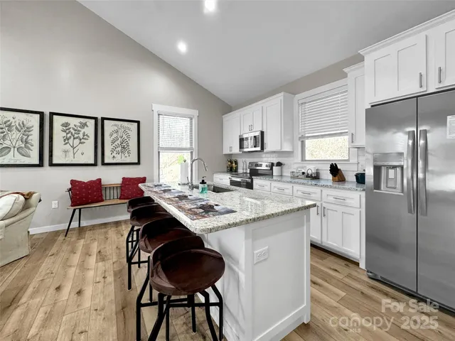 a kitchen with granite countertop a sink stove and refrigerator
