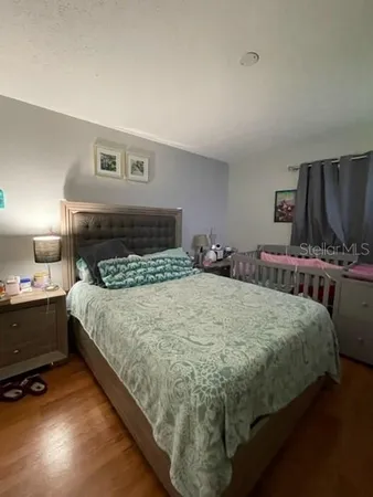 a bedroom with a bed and a lamp on dresser