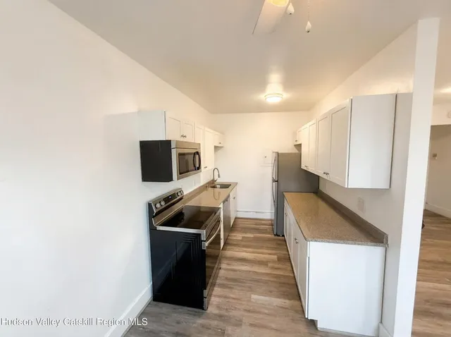 a view of a kitchen with a sink and wooden floor