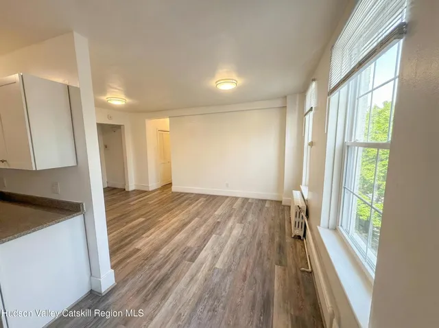 a view of a room with wooden floor and a window