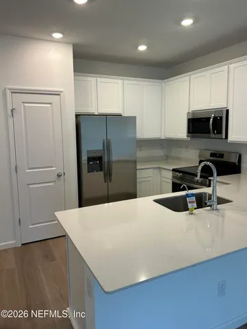 a kitchen with stainless steel appliances a refrigerator sink and microwave
