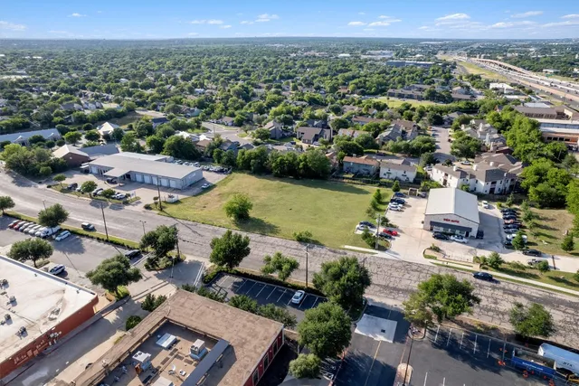an aerial view of a city with lots of residential buildings and mountain view in back
