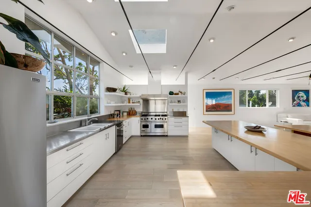 a large white kitchen with lots of counter space and window