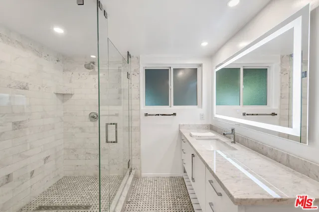 a bathroom with a double vanity sink toilet and shower