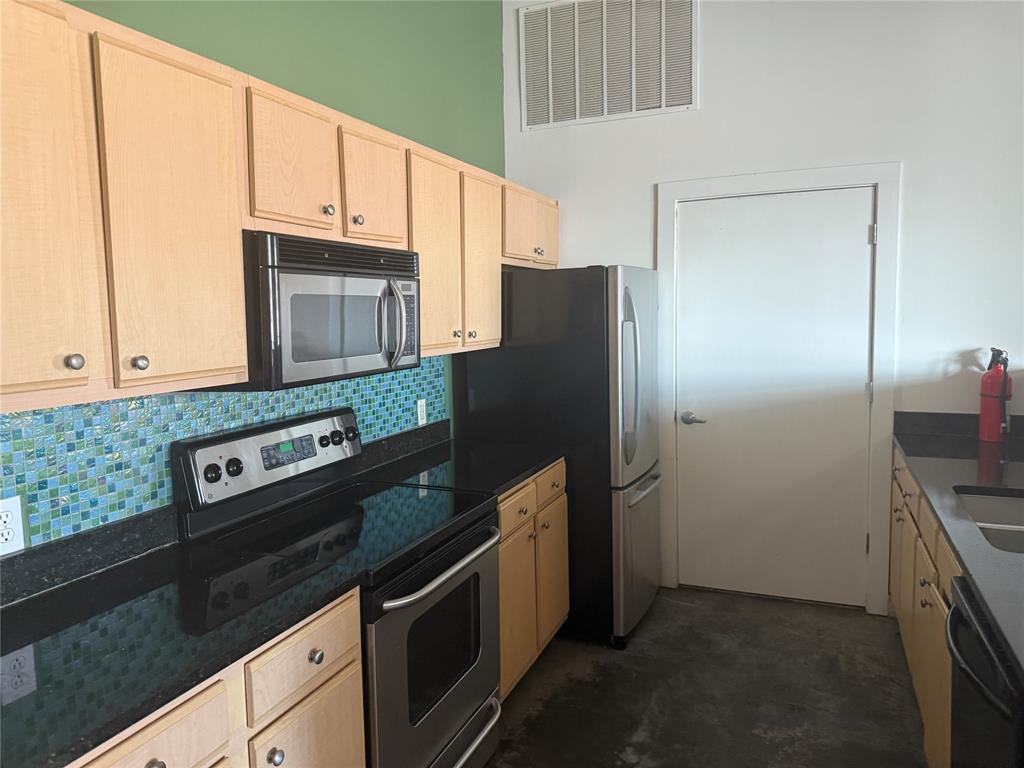 2502 Live Oak Street, Unit 228 Dallas, TX 75204 - Photo 4 of 21 a kitchen with granite countertop a refrigerator stove and microwave
