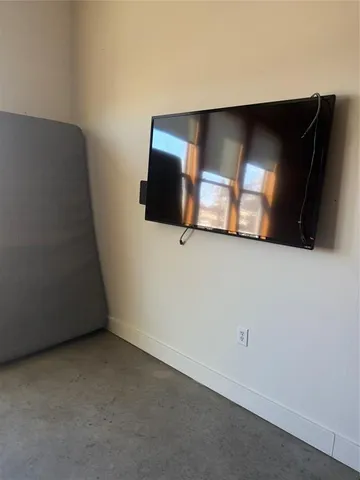 a view of an empty room with wooden floor and windows