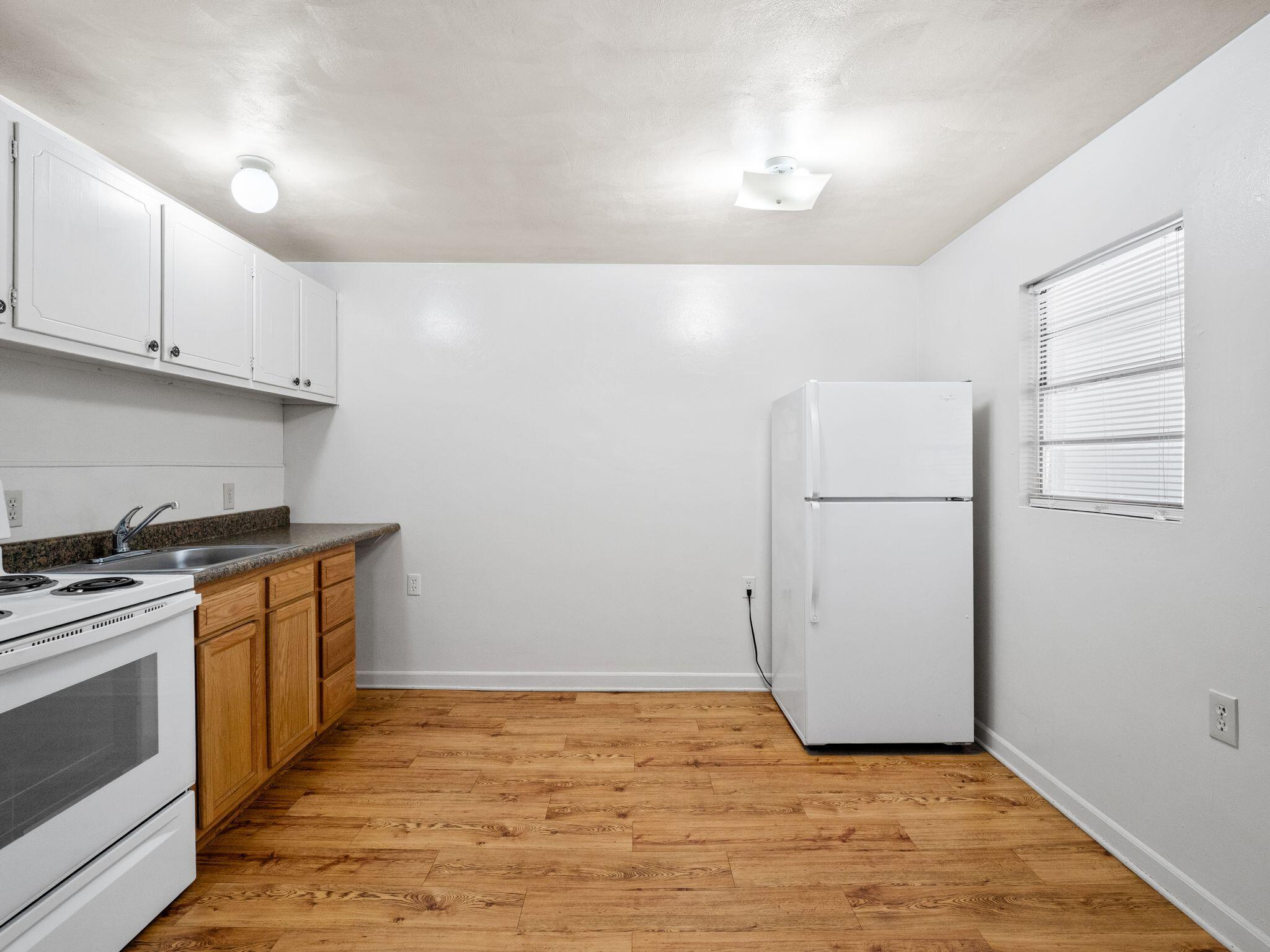 300 Ridgeview Lane, Unit 59 Bassett, VA 24055 - Photo 19 of 23 a kitchen with a stove a refrigerator and white cabinets