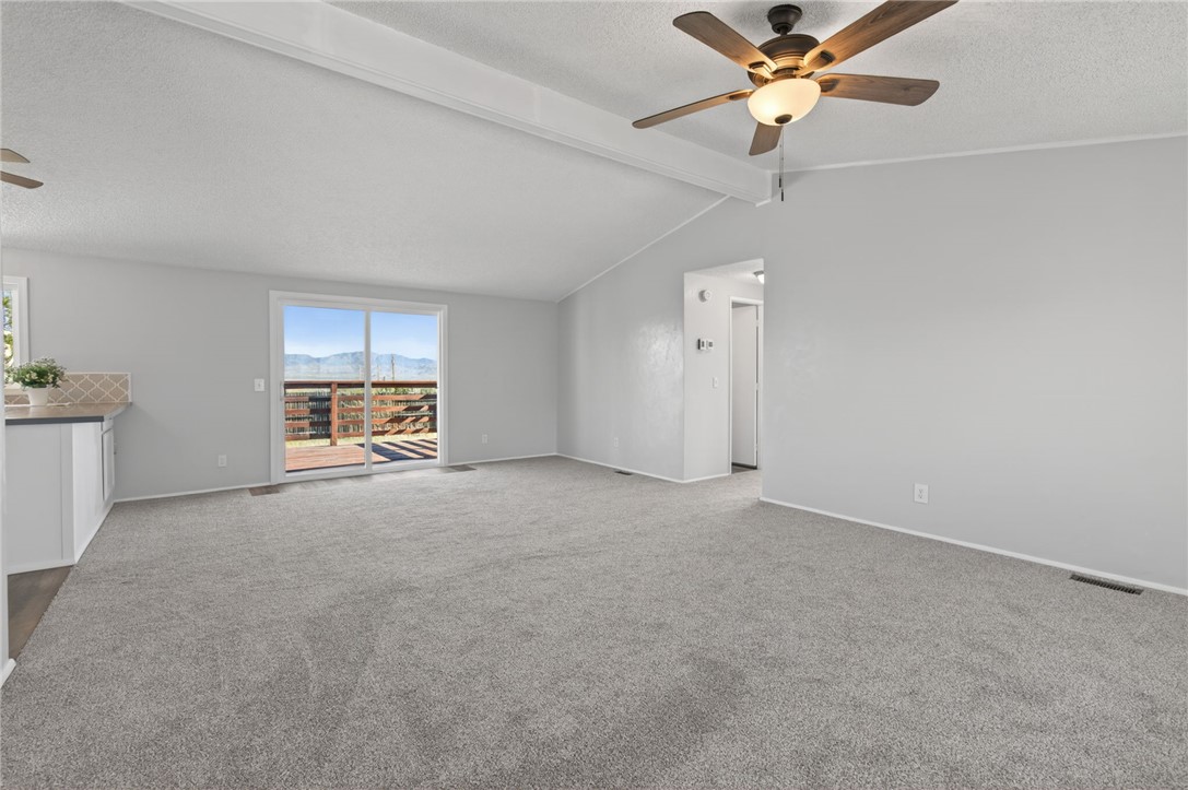 2294 South Dragoon Road Golden Valley, AZ 86413 - Photo 21 of 35 Unfurnished living room featuring a ceiling fan, carpet floors, a mountain view, and a textured ceiling