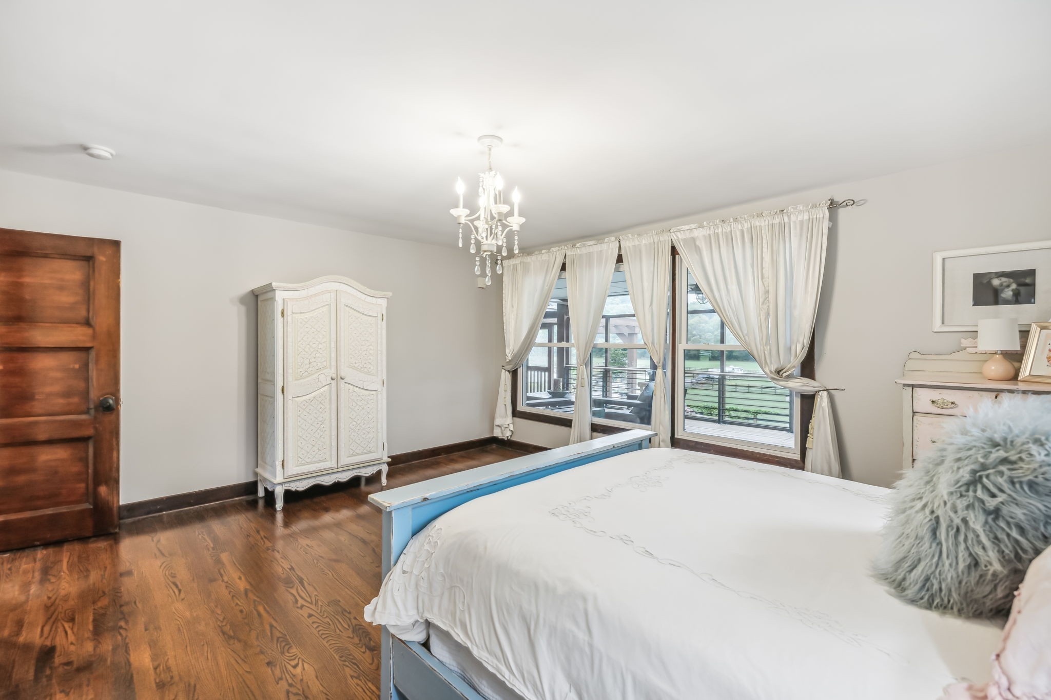 2864 Sawyer Bend Road Nashville, TN 37221 - Photo 46 of 94 a spacious bedroom with a bed a chandelier and large window