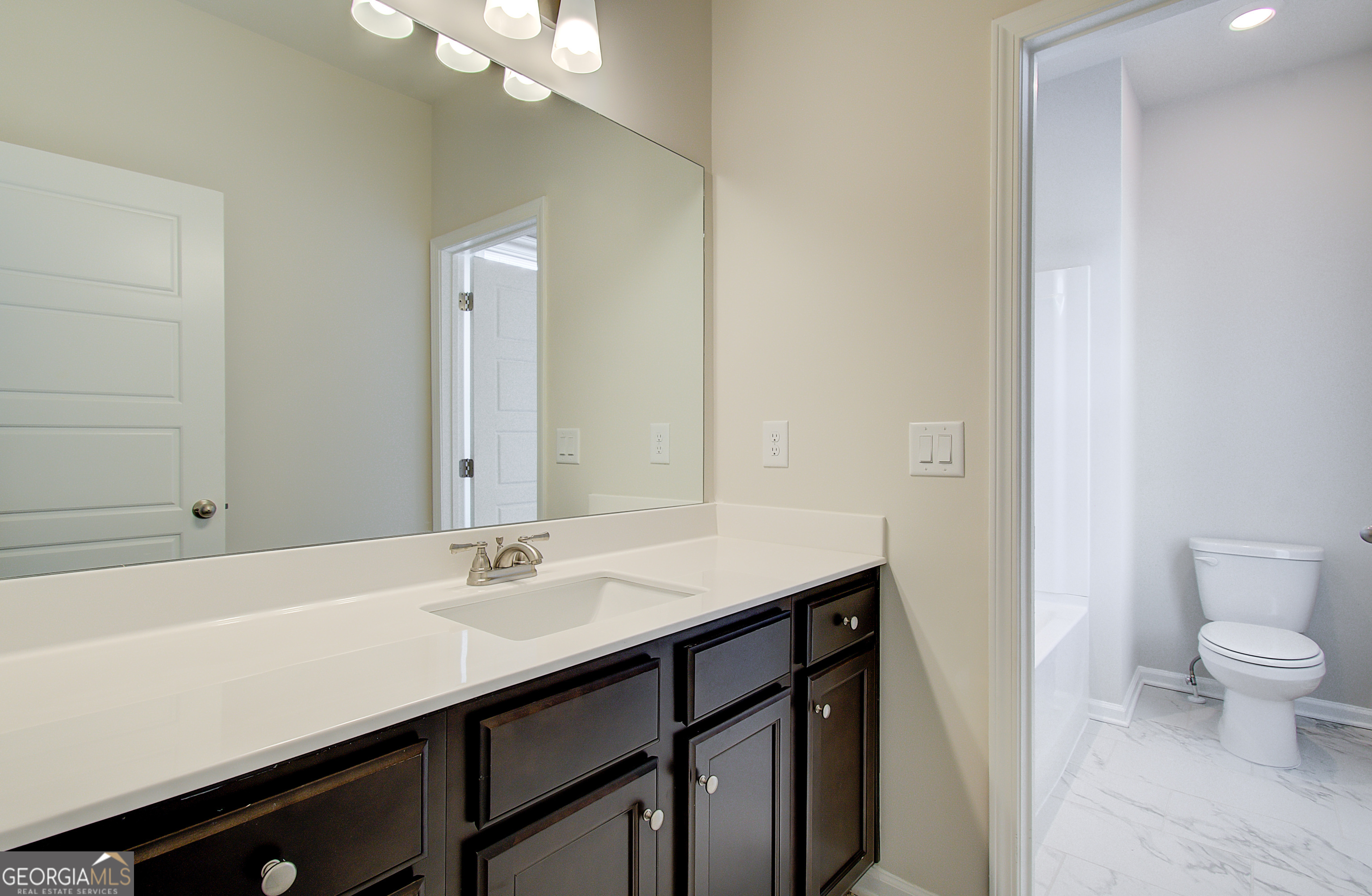 71 Avian Way, Unit 17B Auburn, GA 30011 - Photo 20 of 32 a bathroom with a sink a toilet and a mirror