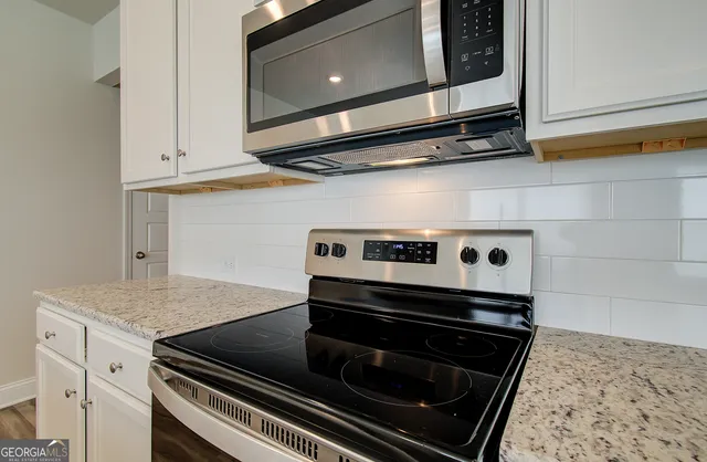 a stove top oven sitting inside of a kitchen