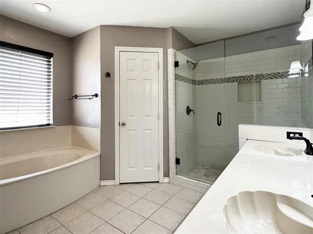 a bathroom with a tub shower and sink