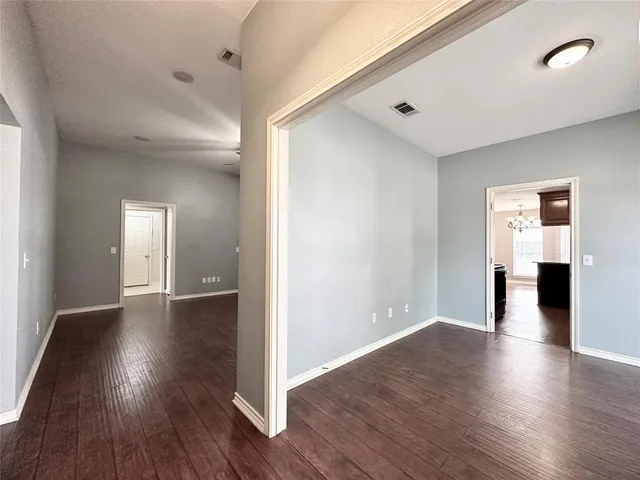 a view of a big room with wooden floor and windows