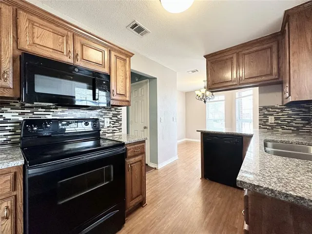 a kitchen with wooden cabinets and stainless steel appliances