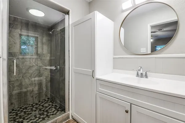 a bathroom with a sink a glass door and a mirror