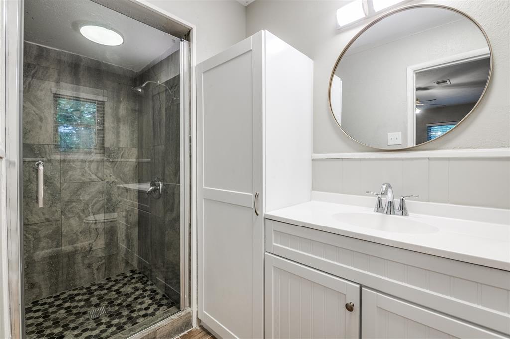 1533 East Springcrest Circle Lancaster, TX 75134 - Photo 21 of 25 Shower with glass enclosure, mosaic tile floor, and large format wall tiles