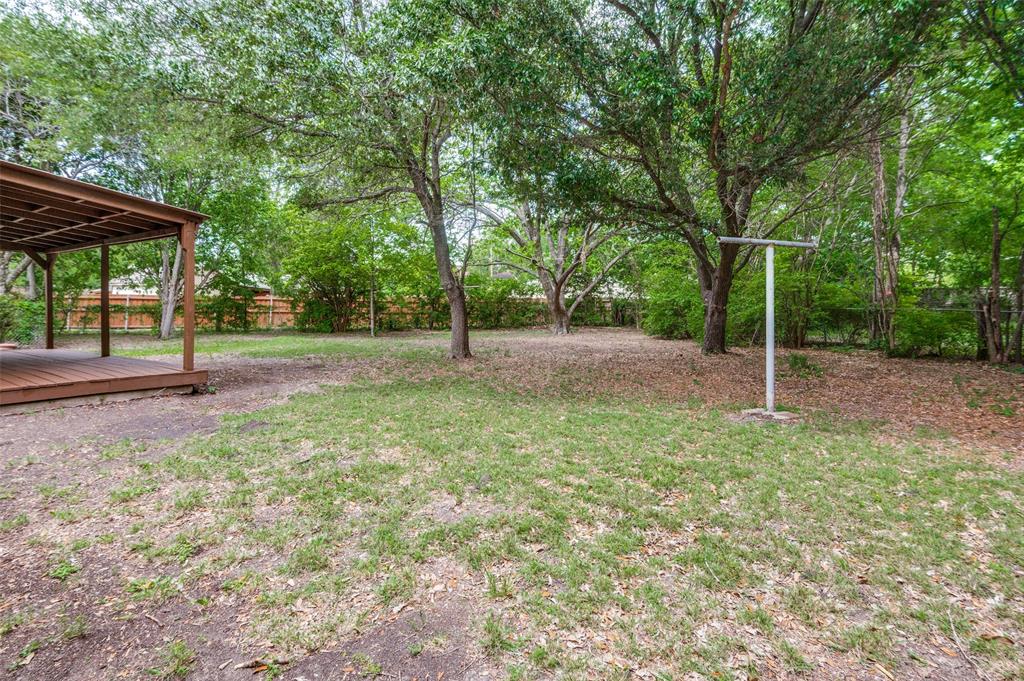 1533 East Springcrest Circle Lancaster, TX 75134 - Photo 24 of 25 Expansive backyard featuring a covered patio, established trees, a grassy area, and perimeter fencing