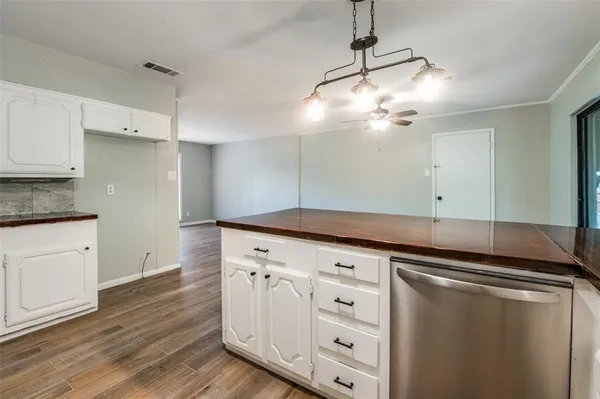 a kitchen with white cabinets and chandelier