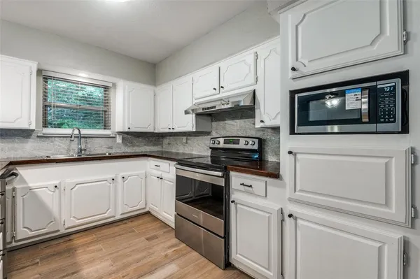 a kitchen with stainless steel appliances white cabinets and a sink