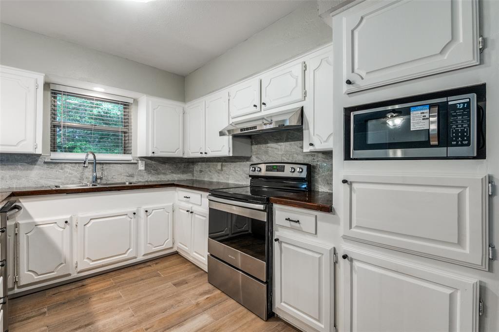 1533 East Springcrest Circle Lancaster, TX 75134 - Photo 10 of 25 Kitchen featuring white cabinetry, dark countertops, a stainless steel range, and a built-in microwave
