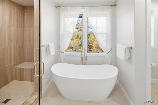 a white bath tub sitting in a bathroom next to a window