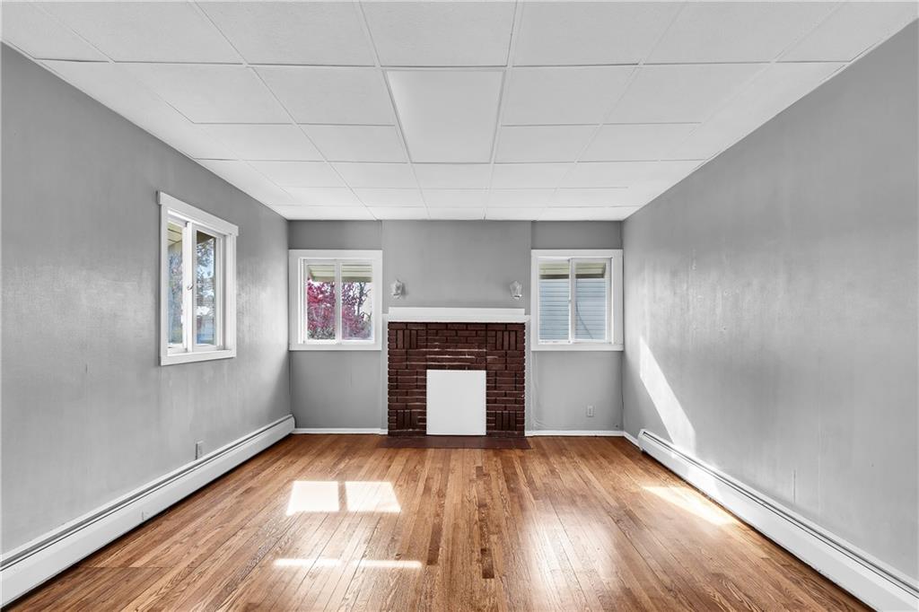 825 Walnut Street Rochester, PA 15074 - Photo 5 of 24 a view of empty room with wooden floor and fireplace