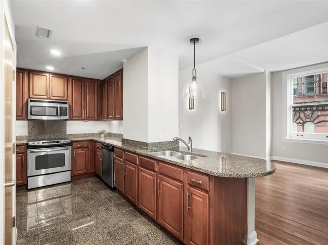 a kitchen with stainless steel appliances granite countertop a stove a sink and a refrigerator