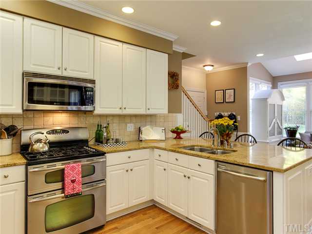 408 Reedham Way Raleigh, NC 27615 - Photo 12 of 25 Kitchen has a back staircase leading upstairs. There's also a door to the garage with room right inside for book bags and jackets.