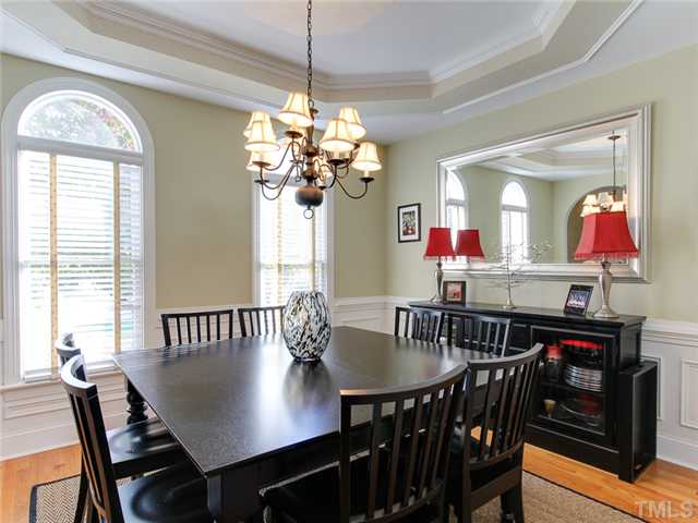 408 Reedham Way Raleigh, NC 27615 - Photo 7 of 25 Dining room has trey ceiling, hardwood floors, wainscoting, and arched transoms above windows.