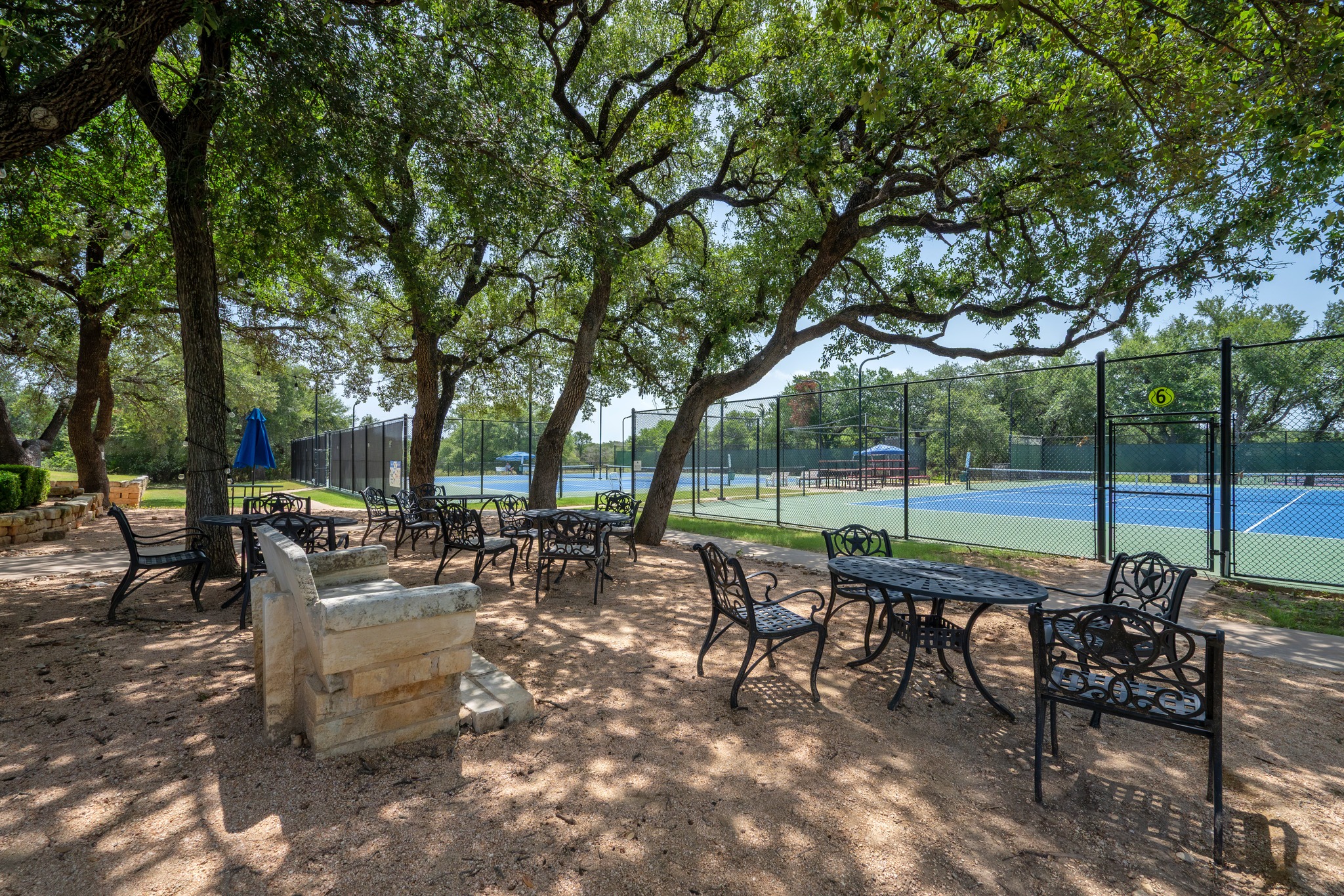 30115 Sawgrass Trail Georgetown, TX 78628 - Photo 35 of 37 Shady outdoor seating alongside multiple tennis courts offers a perfect spot for relaxation.