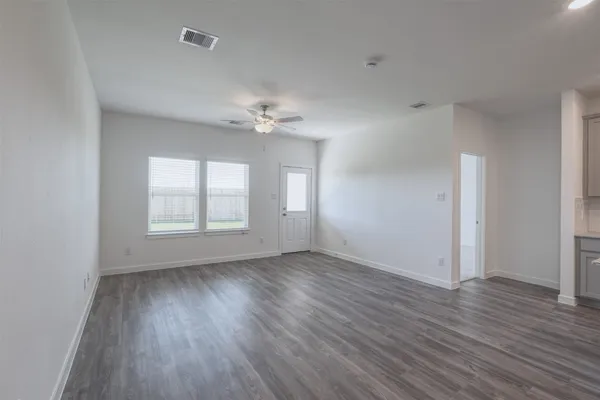 an empty room with wooden floor and window