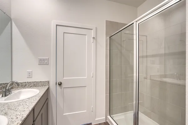 a bathroom with a granite countertop sink shower and a mirror