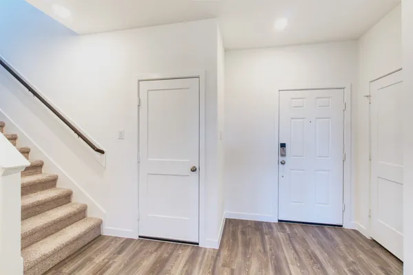 a view of a hallway with wooden floor and entryway