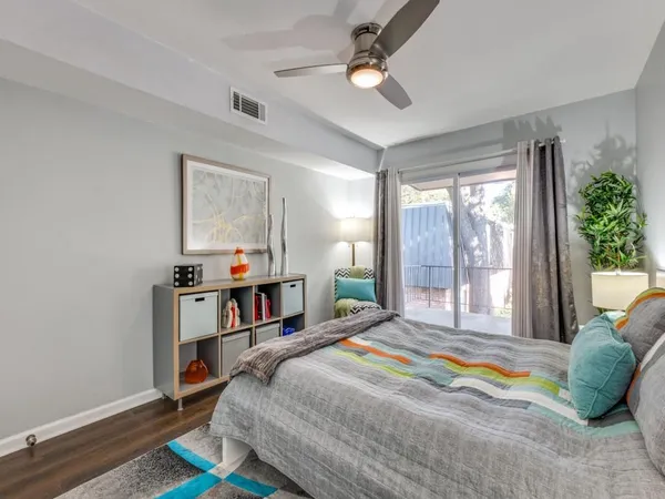 a bedroom with a bed wooden floor and window